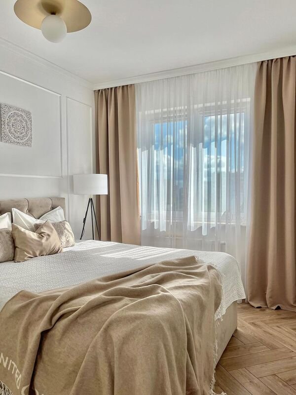Minimalist beige bedroom with curtains