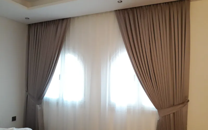 custom curtains dubai — modern living room with floor-to-ceiling drapes